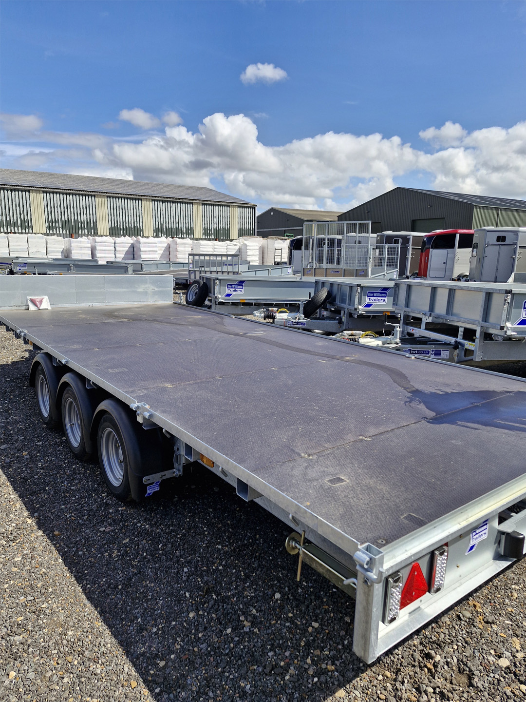 Ifor Williams LM187 flatbed trailer with three axles and headboard