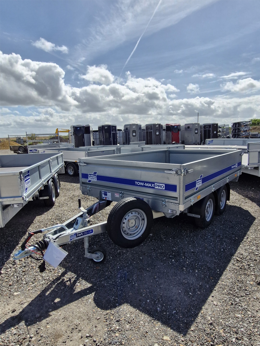Ifor Williams Tow-Max Pro flatbed trailer with blue striped side in yard